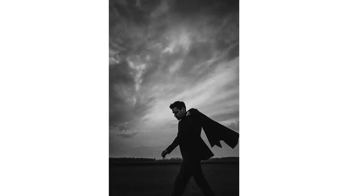 Coat prompt: Man tossing coat in empty field under dramatic sky, black-and-white analog style – ChatGPT AI Photo Editing Prompt